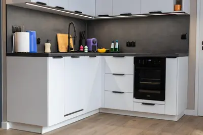 a kitchen with white cabinets and a black stove at LIFESTYLE Apartments in Bochnia