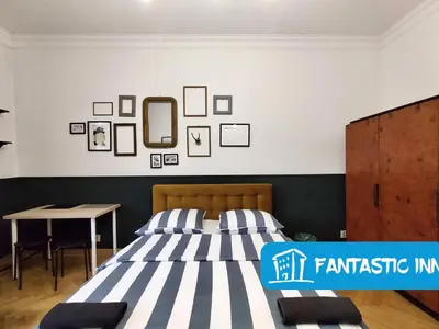 a bedroom with a bed and a table at Fantastic-Inn Kraków - Słowackiego in Kraków