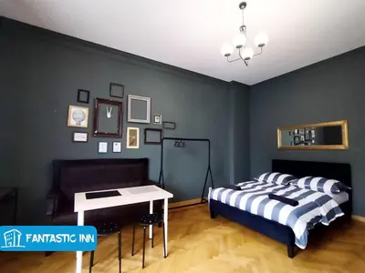 a bedroom with a bed and a table in it at Fantastic-Inn Kraków - Słowackiego in Kraków