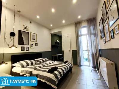 a room with three beds in a room at Fantastic-Inn Kraków - Słowackiego in Kraków
