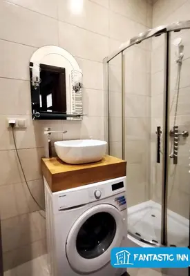 a bathroom with a washing machine and a sink at Fantastic-Inn Kraków - Słowackiego in Kraków