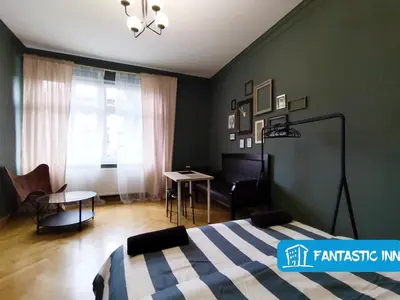 a bedroom with a bed and a table and chairs at Fantastic-Inn Kraków - Słowackiego in Kraków