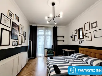 a bedroom with a bed and pictures on the walls at Fantastic-Inn Kraków - Słowackiego in Kraków