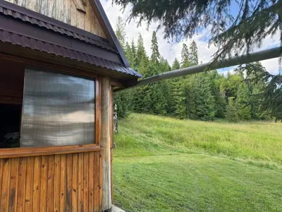 a window on the side of a building next to a field at Terenowka Bacowka in Waksmund