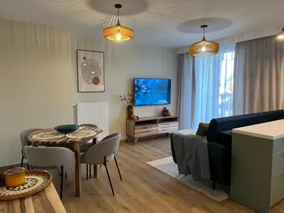 a living room with a couch and a table with chairs at Nowy apartament Saska, z parkingiem in Kraków