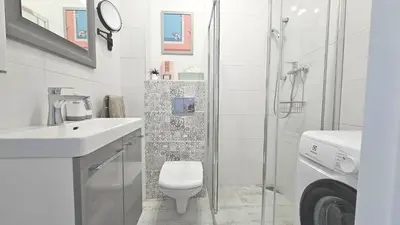 a white bathroom with a toilet and a shower at Blue Salt in Wieliczka