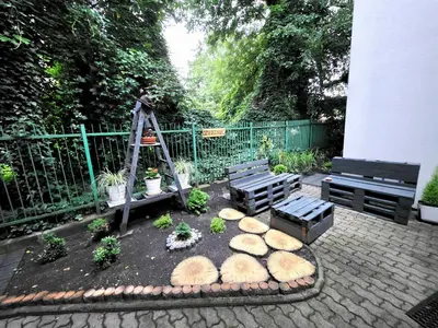 a patio with two benches and a garden with plants at Mieszkanie 3 in Kraków