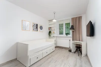 a white bedroom with a bed and a desk at Park Krakowski Comfy Studio by BookingHost in Kraków