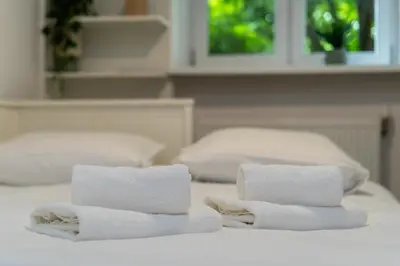 three towels sitting on top of a bed at Park Krakowski Comfy Studio by BookingHost in Kraków