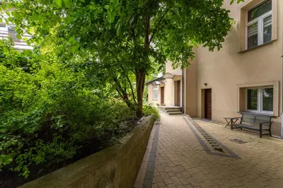 a walkway with a bench in front of a building at Park Krakowski Comfy Studio by BookingHost in Kraków