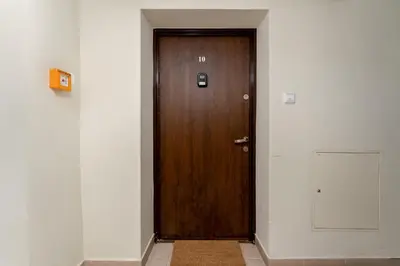 a wooden door in a hallway with a white wall at Park Krakowski Comfy Studio by BookingHost in Kraków