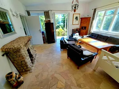 a living room with a couch and a fireplace at Dom z tarasem wśród pól i lasu - przestronny salon, blisko natury in Lubień