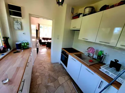 a kitchen with white cabinets and a counter top at Dom z tarasem wśród pól i lasu - przestronny salon, blisko natury in Lubień