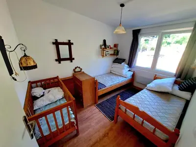 a small room with two beds and a window at Dom z tarasem wśród pól i lasu - przestronny salon, blisko natury in Lubień