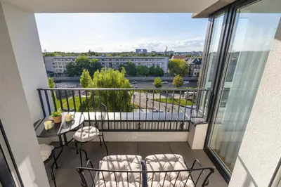 a balcony with a table and chairs and a view at Prandoty Stylish Apartment with Balcony & Parking in Cracow Old Town by Renters Prestige in Kraków