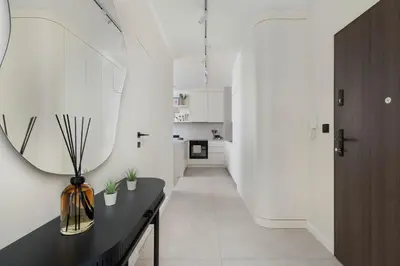 a hallway with a black table and a mirror at Prandoty Stylish Apartment with Balcony & Parking in Cracow Old Town by Renters Prestige in Kraków