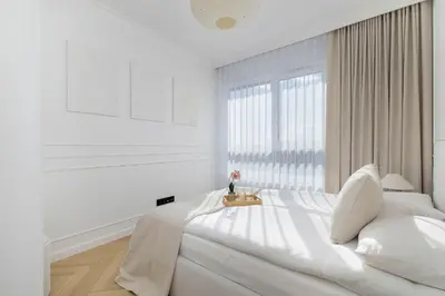a white bedroom with a large bed and a window at Prandoty Stylish Apartment with Balcony & Parking in Cracow Old Town by Renters Prestige in Kraków