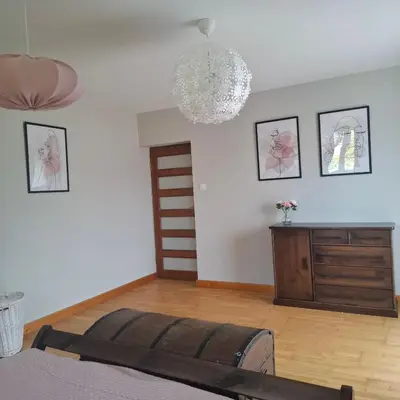 a bedroom with a bed and a chandelier at Apartamenty TUTERRA III in Zabagnie