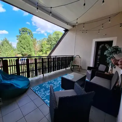 a screened in porch with chairs and a blue rug at Apartamenty TUTERRA III in Zabagnie