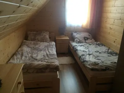 two beds in a small room with a window at Domek z widokiem na góry in Targoszów