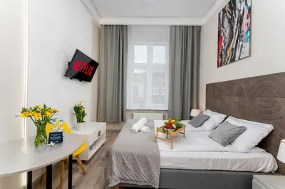 a small bedroom with a bed and a table at Malila Premium Apartments Cracow Sebastiana 27 in Kraków