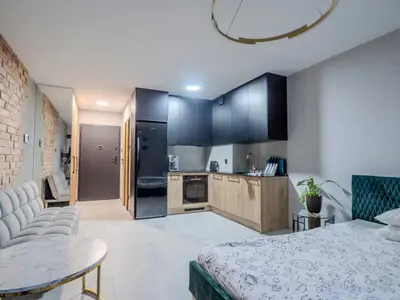 a bedroom with a bed and a kitchen at Nice time in Hart of Cracow,Gym&Pool&Sauna and free parking in Kraków