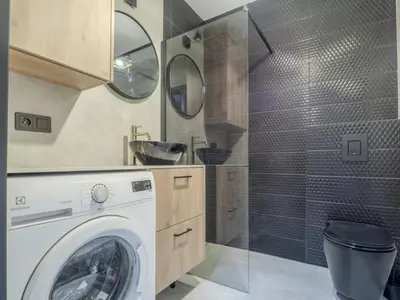 a washing machine in a bathroom with a shower at Nice time in Hart of Cracow,Gym&Pool&Sauna and free parking in Kraków