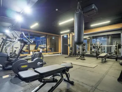 a gym with tread machines and a punching bag at Nice time in Hart of Cracow,Gym&Pool&Sauna and free parking in Kraków