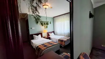 a hotel room with two beds and a mirror at Zielona Paszkówka - sauna! in Paszkówka
