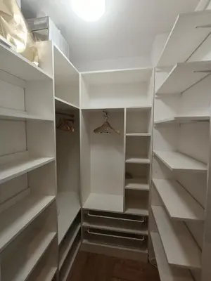 a white walk in closet with white shelves at Apartament Maria in Oświęcim