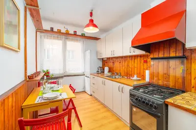 a kitchen with white cabinets and a black stove at Kraszewskiego Apt - Balcony, Park & River nearby - by Rentujemy in Kraków