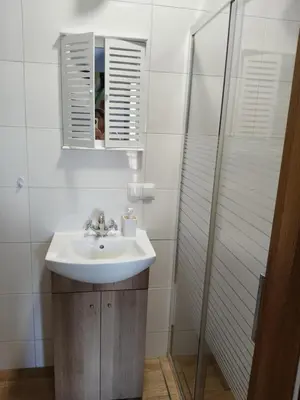 a white bathroom with a sink and a mirror at Słoneczne apartamenty Zator blisko Energylandii in Zator