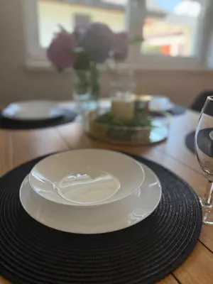 a white plate sitting on a wooden table with glasses at Zator Domki Dreampark in Zator