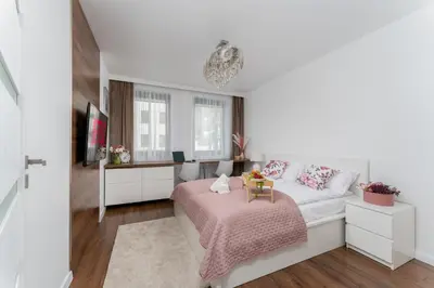 a white bedroom with a bed and a desk at Malila Premium Apartments Cracow Cystersów 20D in Kraków