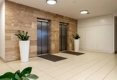 a hallway with three elevators with plants in them at Malila Premium Apartments Cracow Cystersów 20D in Kraków