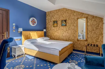 a blue bedroom with a bed and a mirror at Czeczotka Palace Apartments in Kraków