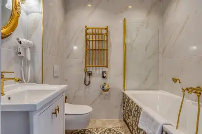 a bathroom with a tub and a toilet and a sink at Czeczotka Palace Apartments in Kraków