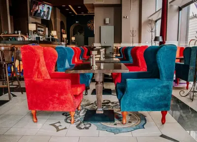 a restaurant with red and blue chairs and a table at Czeczotka Palace Apartments in Kraków