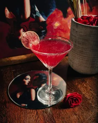 a red drink in a martini glass on a table at Czeczotka Palace Apartments in Kraków