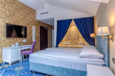 a bedroom with a bed with a desk and a window at Czeczotka Palace Apartments in Kraków