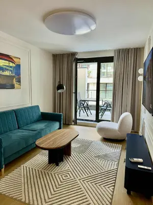 a living room with a blue couch and a table at The Velvet Apartment Kościuszki in Kraków