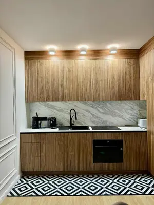 a kitchen with wooden cabinets and a sink at The Velvet Apartment Kościuszki in Kraków