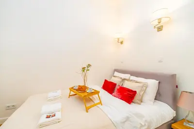 a bedroom with a white bed with red pillows at Kazimierz Apt - Top Location - by Rentujemy in Kraków