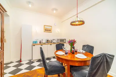 a dining room with a table and chairs and a kitchen at Kazimierz Apt - Top Location - by Rentujemy in Kraków