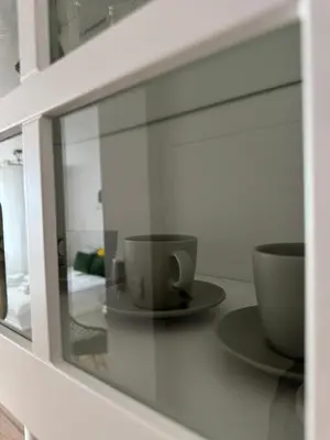 a glass cabinet with two cups and saucers in it at KULIG APART - Długa 82 - Kraków Old Town in Kraków