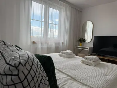 a white bedroom with two beds and a television at KULIG APART - Długa 82 - Kraków Old Town in Kraków