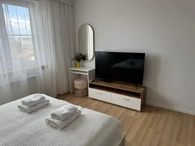 a white room with a television and two towels at KULIG APART - Długa 82 - Kraków Old Town in Kraków