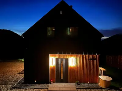 a black house with a door with lights on it at Polana Kasztelana - Beskid Wyspowy in Limanowa