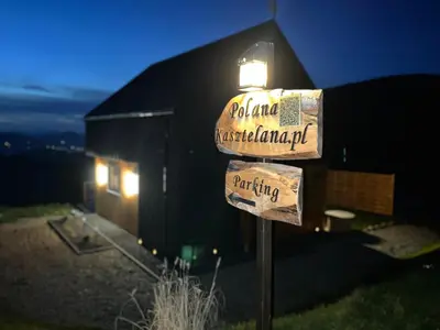 a street sign in front of a building at night at Polana Kasztelana - Beskid Wyspowy in Limanowa