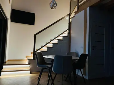 a dining room with a table and chairs and stairs at Polana Kasztelana - Beskid Wyspowy in Limanowa